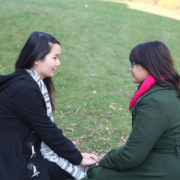 Two people sitting and talking outside